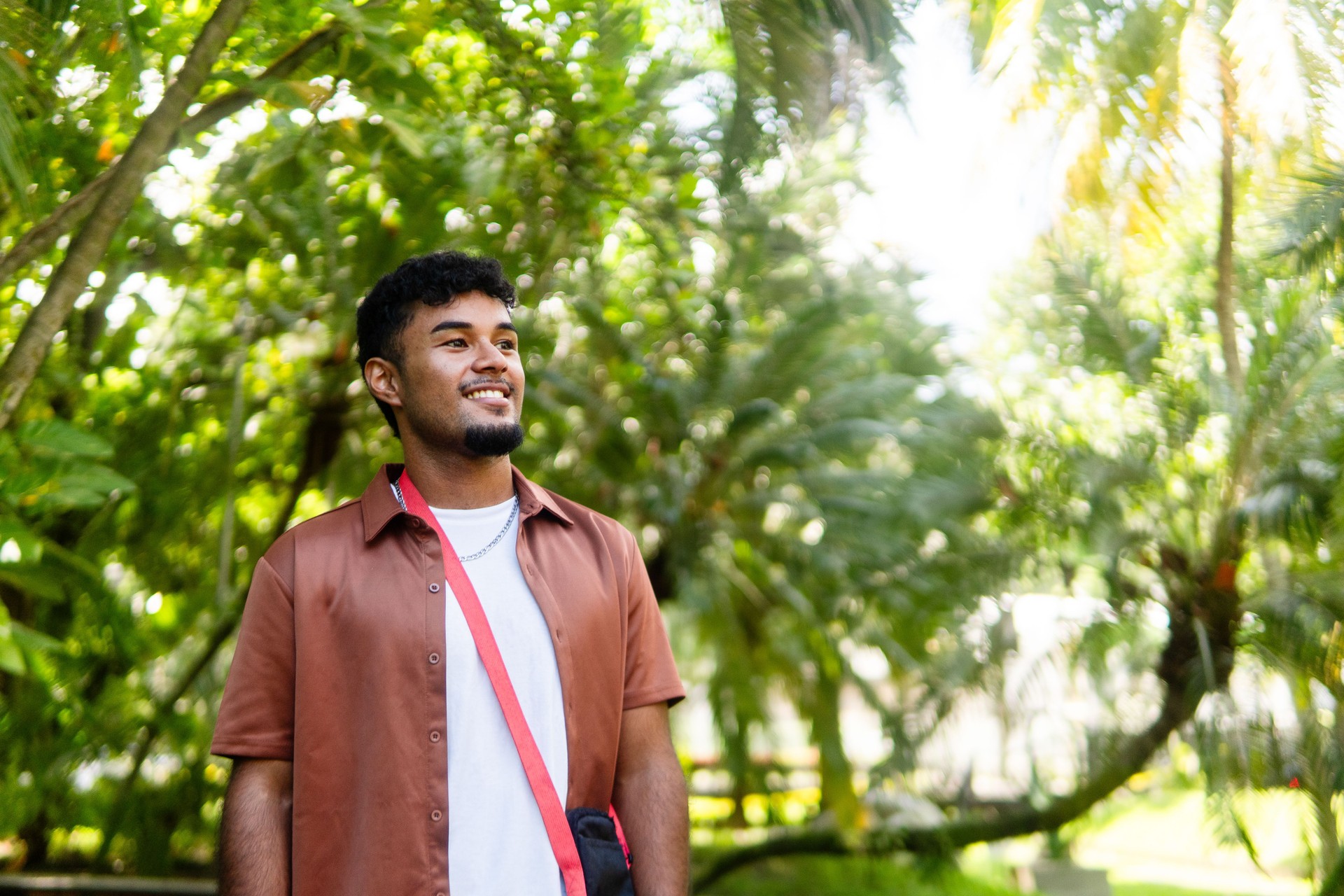 Young hispanic man smiling outdoors on university campus